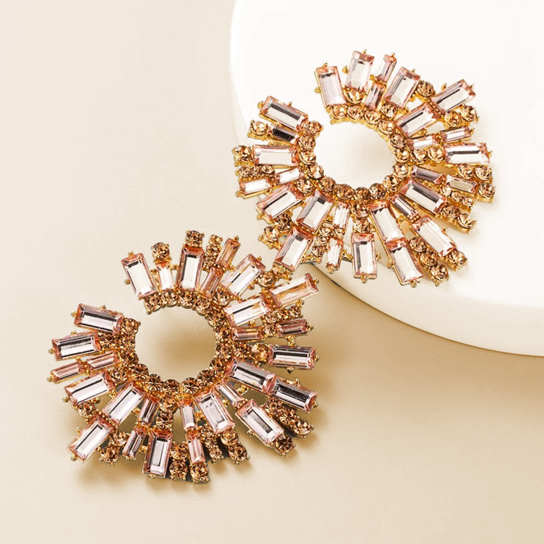 House of Royal Bracha circular rose gold earrings with crystals on plate background
