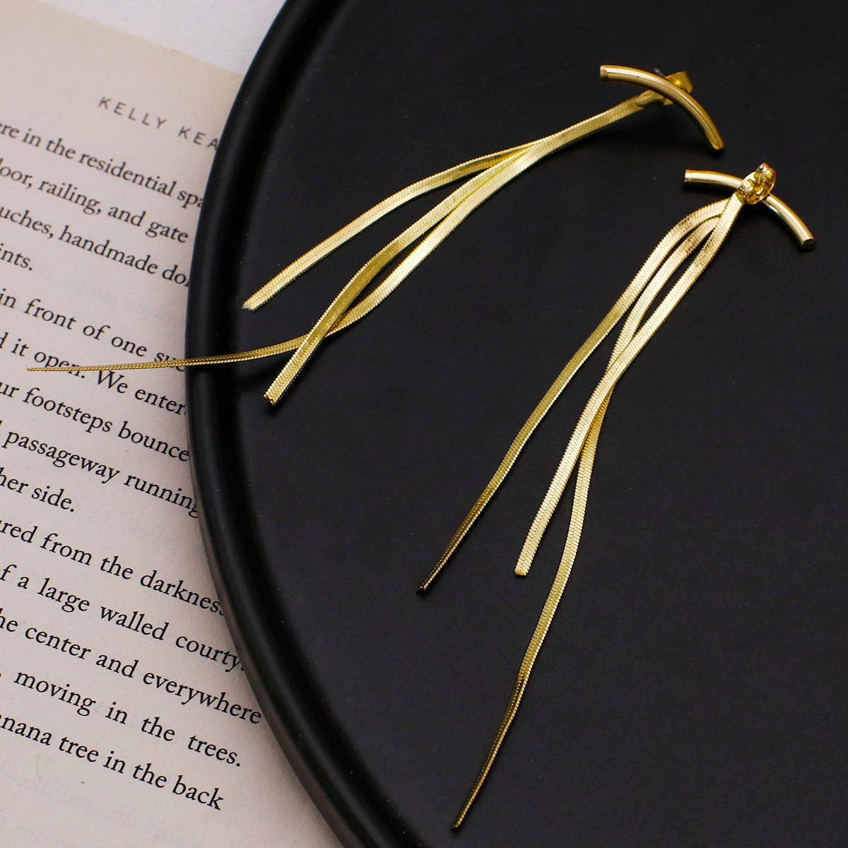 House of Royal ella abstract design gold earrings on black background
