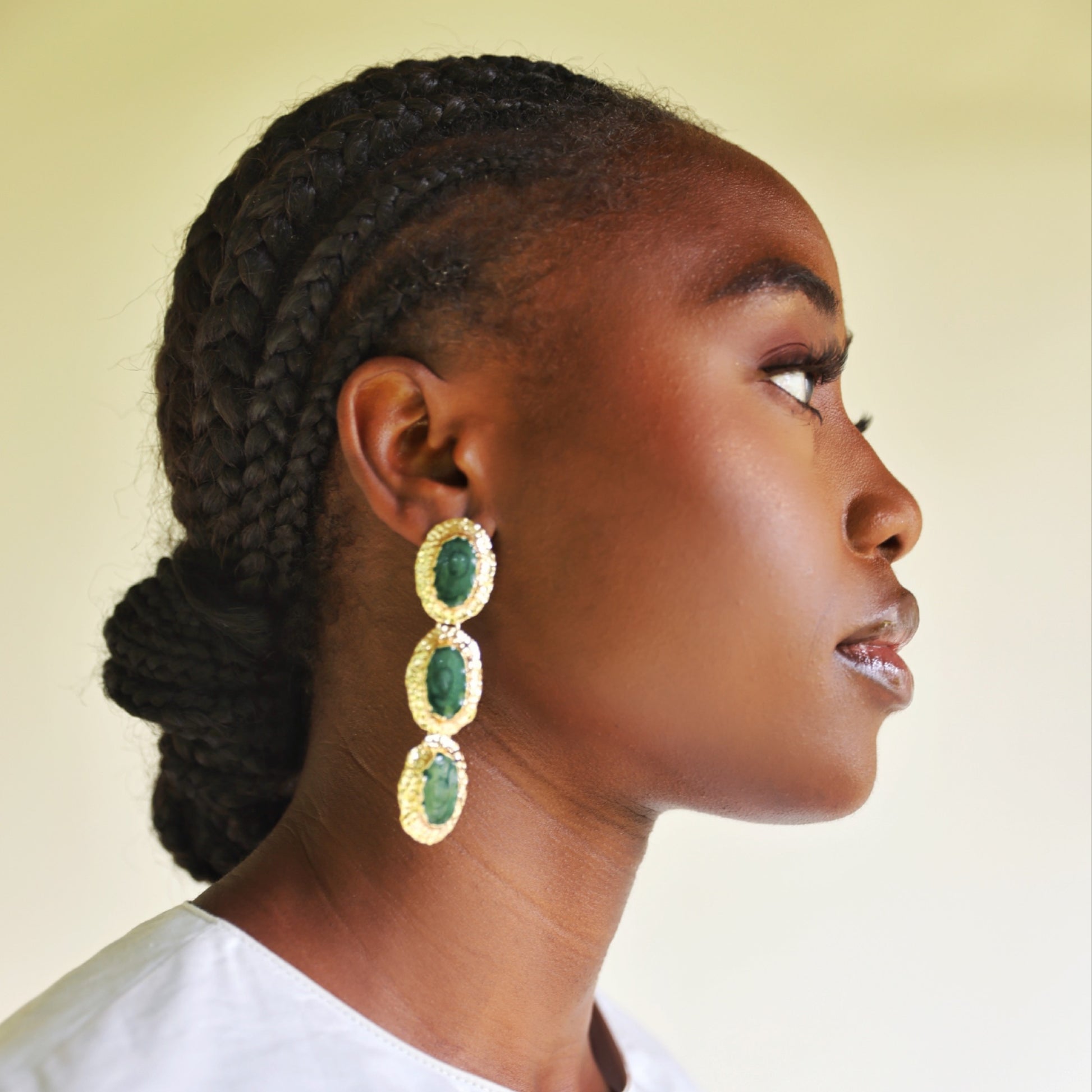 House of Royal Jaffa gold earrings with green gem stones on model