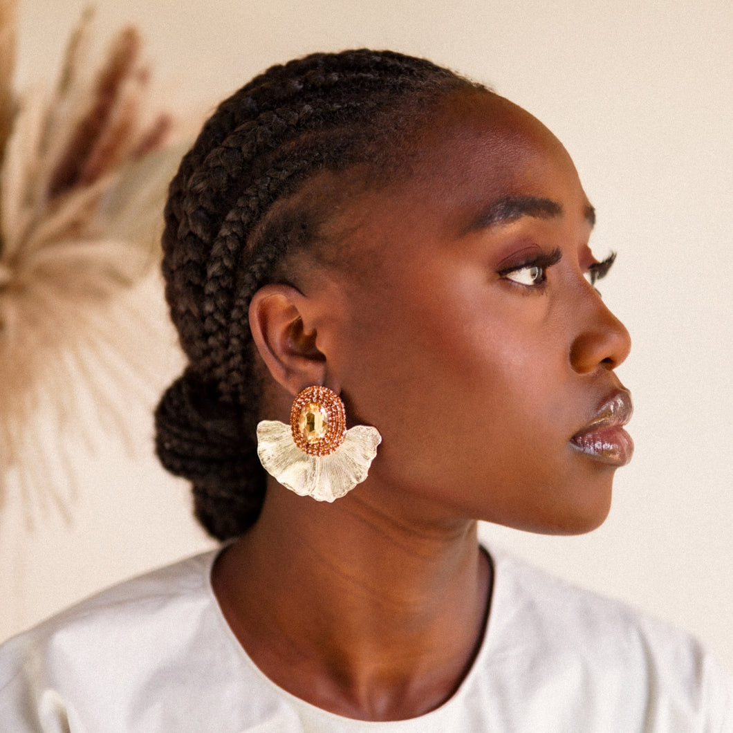 House of Royal Anais statement gold earrings with flower petal and orange gem stone design on model
