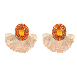 House of Royal Anais statement gold earrings with flower petal and pink gem stone design on plain background