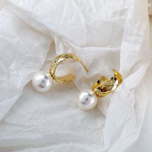 House of Royal Daniela pearl and gold earrings on paper