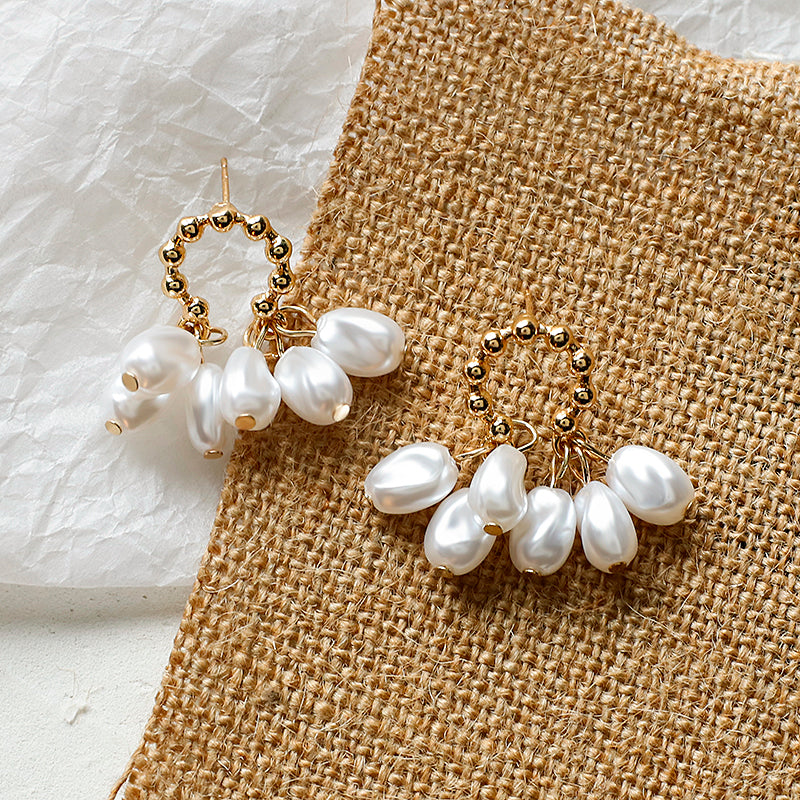 House of Royal Chloe small pearl and gold earrings on fabric background